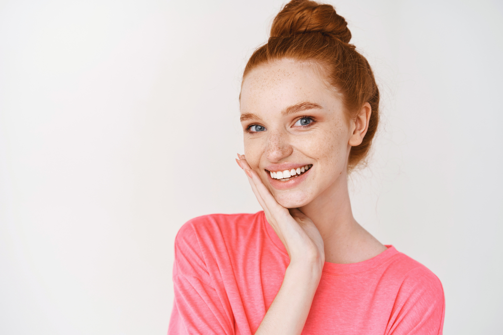 A young woman is happy with the results of her dental crown treatment.